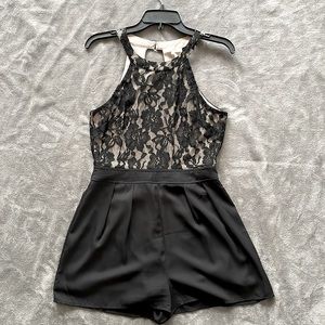 Black lace romper with neck clasp and lower back zipper.